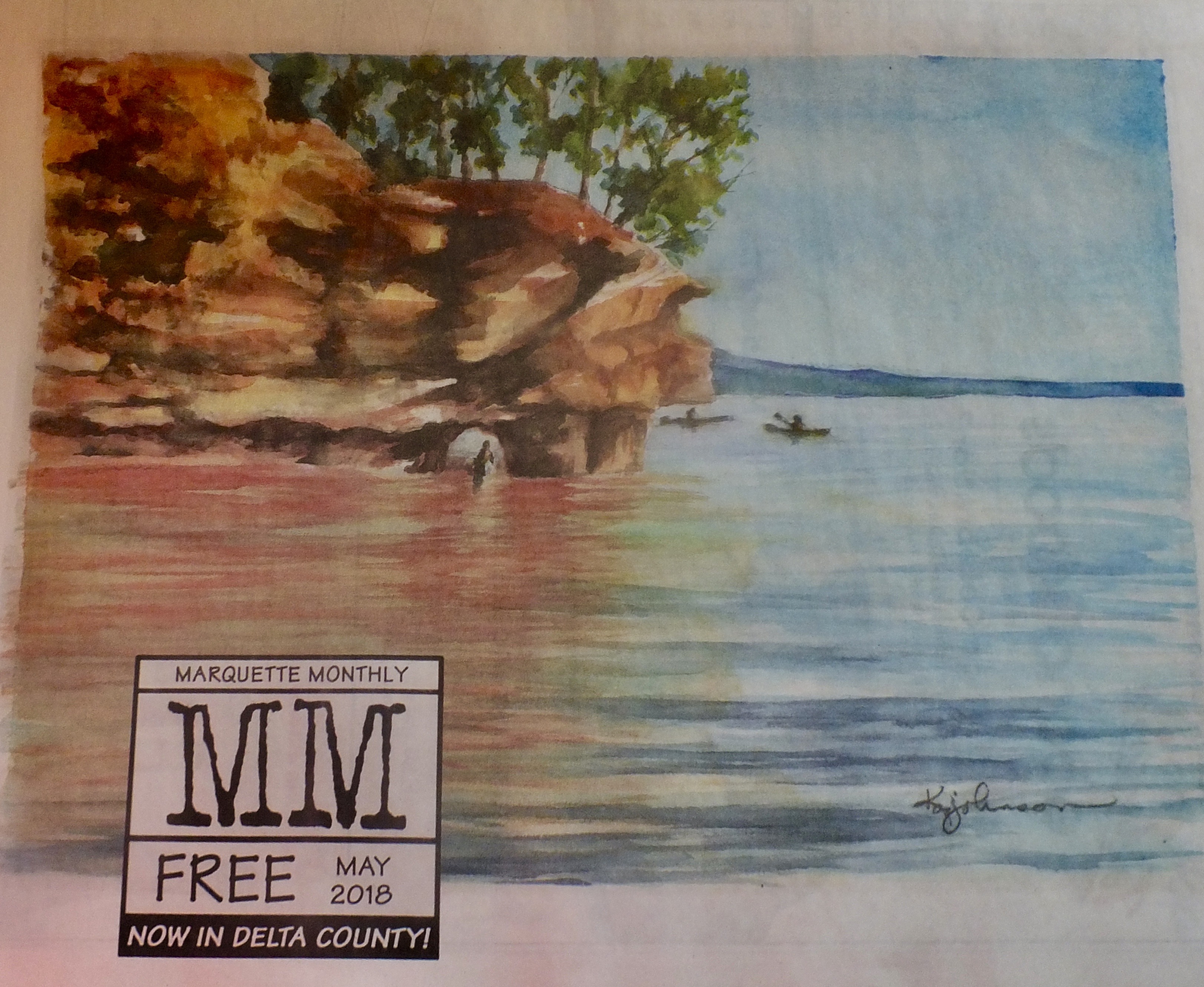 Marquette Monthly magazine cover with red cliffs and water and the letters MM